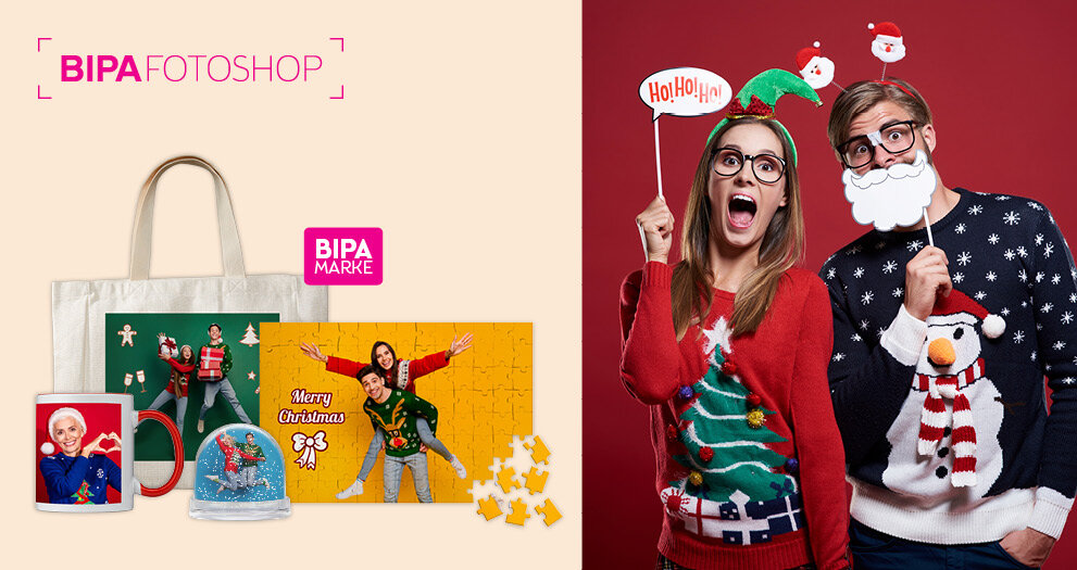 Junges Paar posiert mit Weihnachtsrequisiten, darunter BIPA Fotoshop Geschenkideen wie Tasse, Puzzle oder Schneekugel.