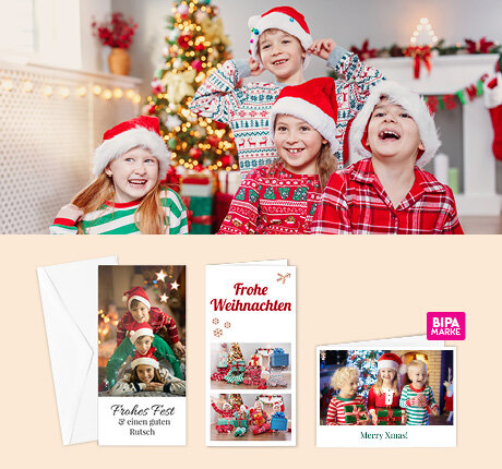 Vier Kinder in Weihnachtsoutfits lachen vor dem Baum, unten BIPA Fotoshop Grußkarten mit eigenen Bildern und festlichen Motiven.
