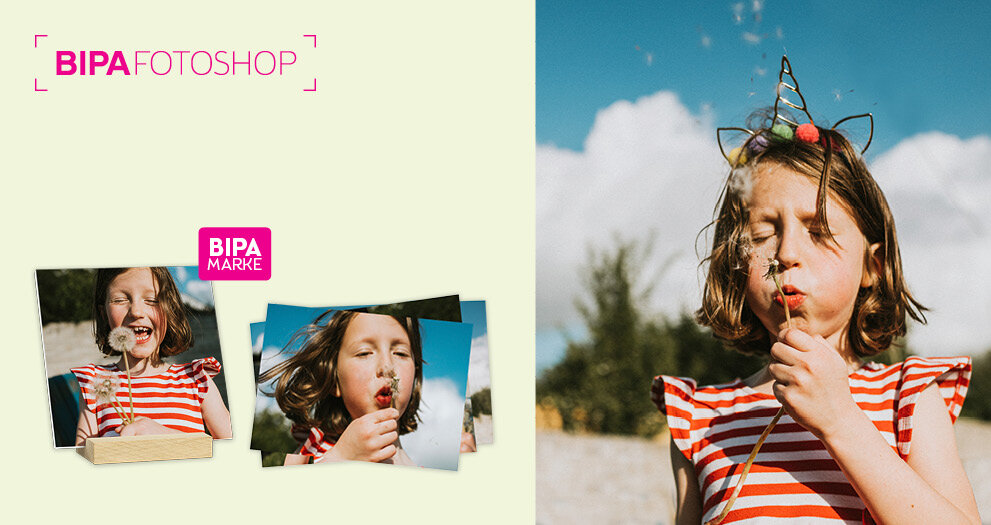 Ein Mädchen pustet lachend Pusteblumen – perfekte Frühlingsmomente als hochwertige Fotoabzüge im BIPA Fotoshop gestalten.