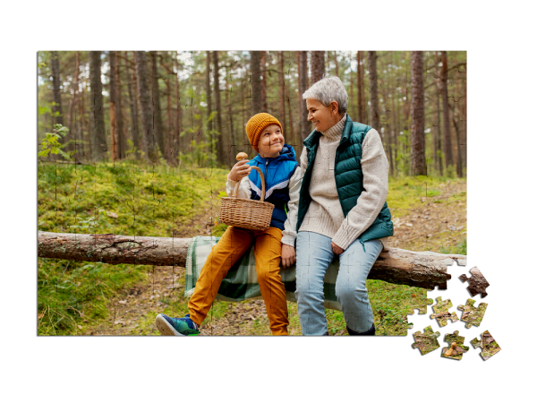 Unfertiges Puzzle zeigt Oma und Kind beim Pilze suchen im Wald, beide sitzen auf einem Baumstamm, Kind hält einen Korb.