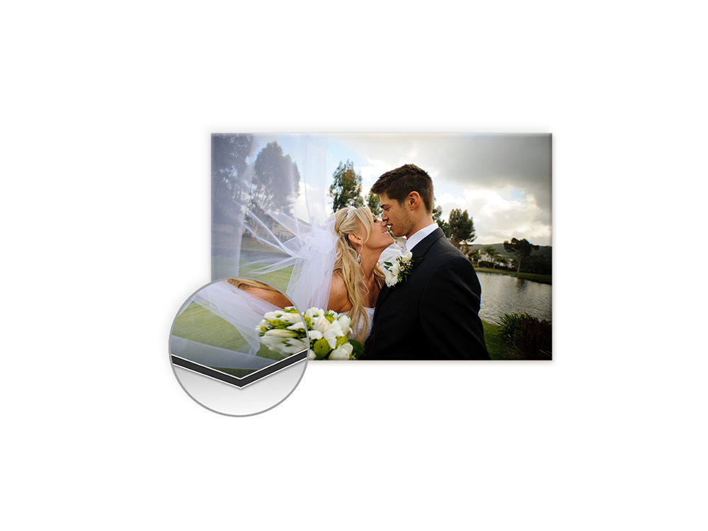 Das Bild zeigt ein frisch verheiratetes Paar, das sich in einem romantischen Moment am See küsst, umgeben von Natur.